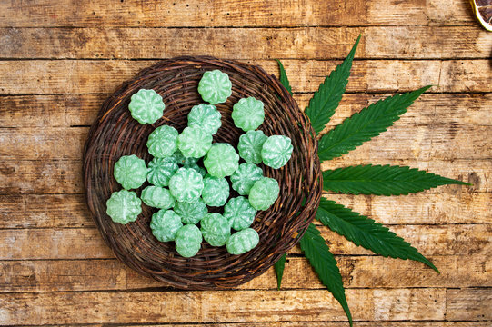 Cannabis Bonbons And Marijuana Leafs On A Table