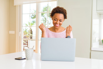 Young african american woman working using computer laptop celebrating surprised and amazed for...
