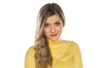 Smiling blonde with makeup, and long wavy hair on white background