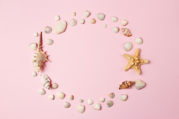 Fototapeta na wymiar Seashells and starfish on a pale pink background. Summer time concept. Top view