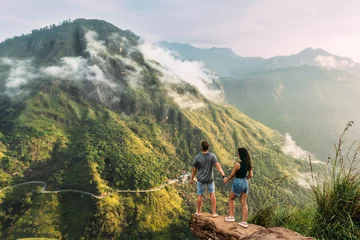 Foto op Aluminium The couple greets the sunrise in the mountains. Man and woman in the mountains. Man and woman holding hands. The couple travels around Asia. Travel to Sri Lanka. Serpentine in the mountains. Honeymoon © MISHA
