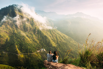 The couple greets the sunrise in the mountains. Man and woman in the mountains. Wedding travel. The...
