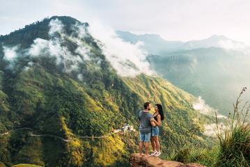 The couple greets the sunrise in the mountains. Man and woman in the mountains. Man and woman...