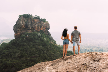A couple in love on a rock admires the beautiful views. Boy and girl on the rock. A couple in love...
