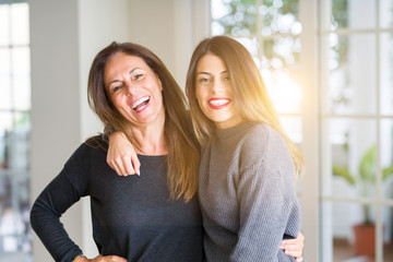 Beautiful family of mother and daughter together, hugging and kissing at home