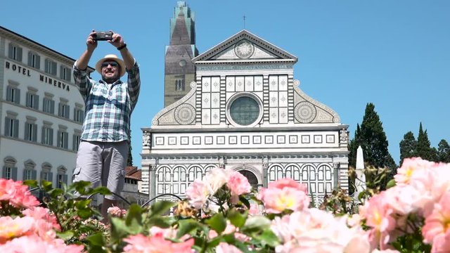 Smiling man taking selfie in front of Santa Maria Novella church, Florence, Italy. Happy people travels to best place of Tuscany, cheerful male tourist visiting Firenze, souvenir photo of holidays
