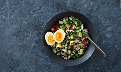 Vegetarian healthy breakfast Bowl summer salad with cucumber, radish, avocado and quinoa top view
