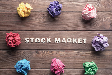 Marketing word on wooden table and paperballs around