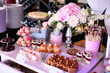 Delicious candy bar with cupcakes, cake pops, macaroons and other sweets