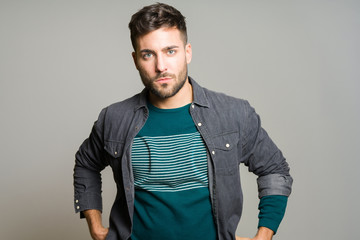 Fototapeta premium Young handsome man possing and modeling over grey isolated background