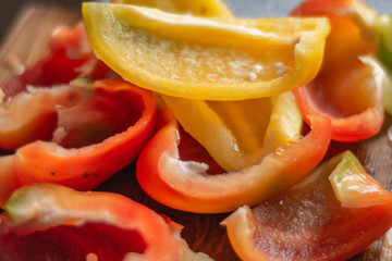 pieces of sliced fresh Bulgarian pepper on a wooden cutting board
