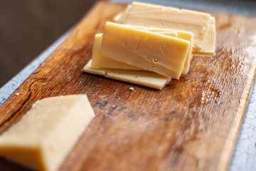 sliced cheese on a chopping wooden board