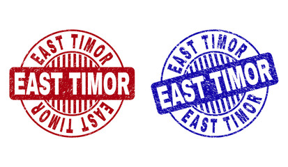 Grunge EAST TIMOR round stamp seals isolated on a white background. Round seals with grunge texture in red and blue colors. Vector rubber imitation of EAST TIMOR tag inside circle form with stripes.