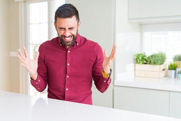 Handsome hispanic business man celebrating mad and crazy for success with arms raised and closed...
