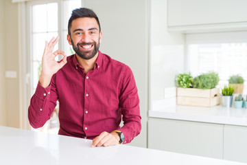 Fototapeta premium Handsome hispanic business man smiling positive doing ok sign with hand and fingers. Successful expression.
