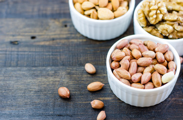 Tasty nuts arrangement in a bowl on a wooden table. Healthy food and snack, organic vegetarian food. Walnut, almond, peanut
