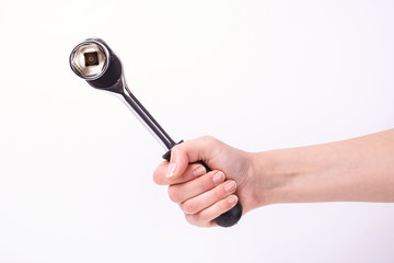 Ratchet wrench in a hand of the girl. Symbol of hard work, feminism and labor day. Isolate on white background.