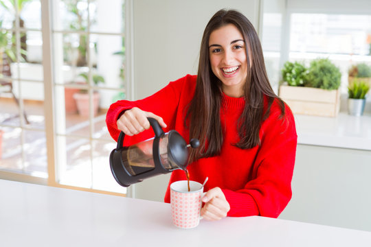 Young beautiful woman making morning coffee smiling, preparing a cup of latte for breakfast