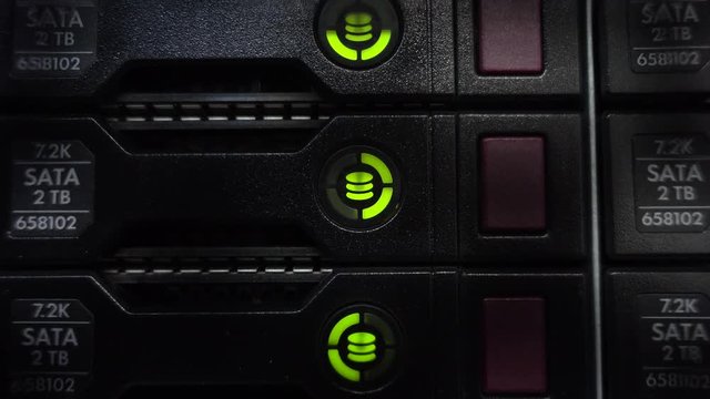 Servers stack with hard drives in a datacenter for backup and data storage. Close up shot. Blink led green.