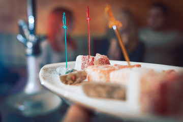 Turkish Delight, oriental sweets on a plate in a restaurant, Arabian interior. eastern tea ceremony. Selective focus, Hookah bar, rest concept