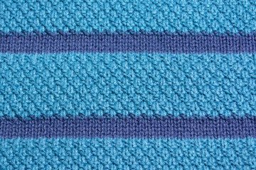 A sample of knitting. Knitted texture. Knitted texture of blue color