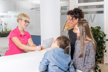 Woman with two Kids at the Dentist getting a medical appointment