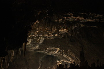 wide angle panoramic view showing the opening of a cave, Thum Lod cave, Bang Ma Pha, in Northern Thailand. Touristed cave with stalagmites and stalactites and a river running thru it.