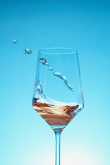 glass of white wine with wave on white background