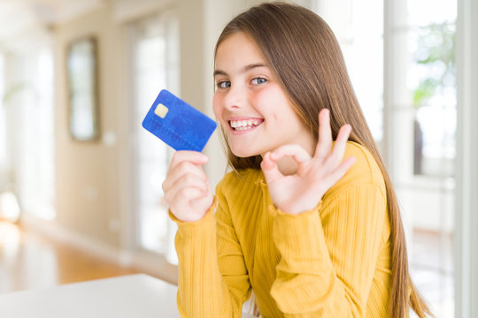 Beautiful Young Girl Kid Holding Credit Card Doing Ok Sign With Fingers, Excellent Symbol