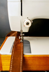 Background type of sewing machine, leather belt sewing process. Leather workshop.