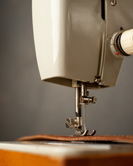 Background type of sewing machine, leather belt sewing process. Leather workshop.