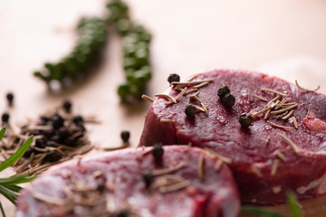 Raw beef fillet steaks with spices on wooden background