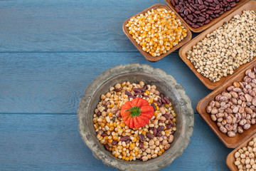 Legumes in the bowl and in the copper cookware on the rustic wooden table