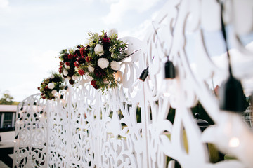 Wedding arch decorated with red flowers