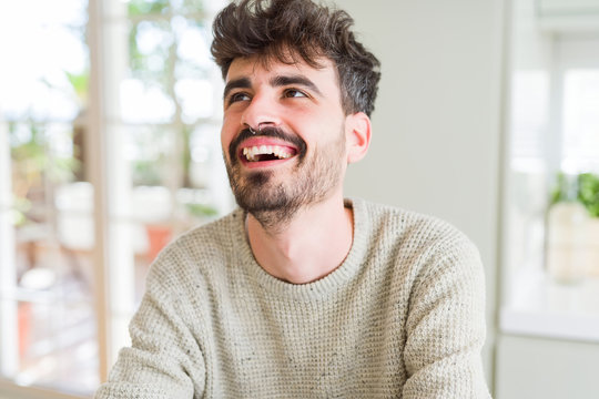 Handsome young man smiling cheerful at the camera with a big smile on face showing teeth