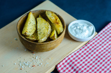Homemade baked potato slices with white garlic sauce 