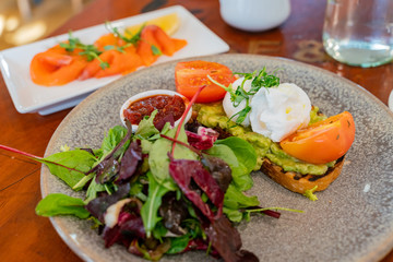 Close up shot of a plate of vegetable salad and smoke salmon slice