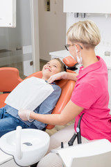 Junge bei Zahnbehandlung lächelt der Zahnarzthelferin zu