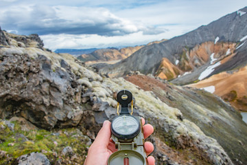 Beautiful colorful volcanic mountains Landmannalaugar and a compass in hands, Iceland