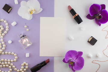 Obraz na płótnie Canvas Girly flat lay background. Violet paper background with lipstick, perfume, orchids and jewelry.