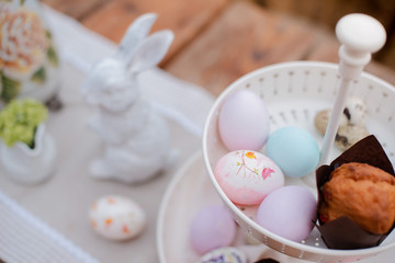 Served festive decorative table garden outdoors. Farm. Rustic style. Willow spring bloom. Flowers cookies glass jar. Easter