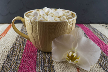 Nice Cup of coffee with marshmallow. Striped fabric background.
