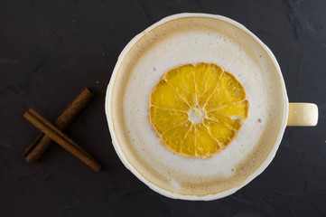 Nice Cup of coffee with dried orange. Dark background.