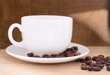 White cup of coffee with coffee beans.