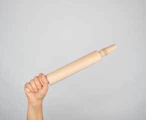 hand holding a wooden rolling pin