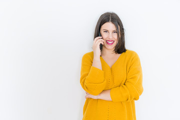 Beautiful brunette young woman smiling confident calling using smartphone over isolated white background wearing casual yellow sweater
