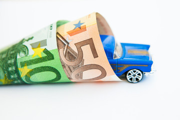 Blue toy car in the banknotes 50 and 100 euros