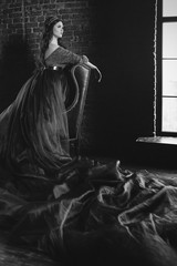monochrome portrait of beautiful young pretty cute woman princess (queen) in long queen's dress and...