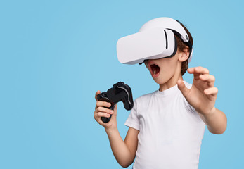 Amazed kid in VR glasses playing game  © kegfire