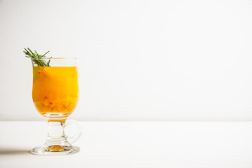 Hot buckthorn beverage in glass. Selective focus. Shallow depth of field. 